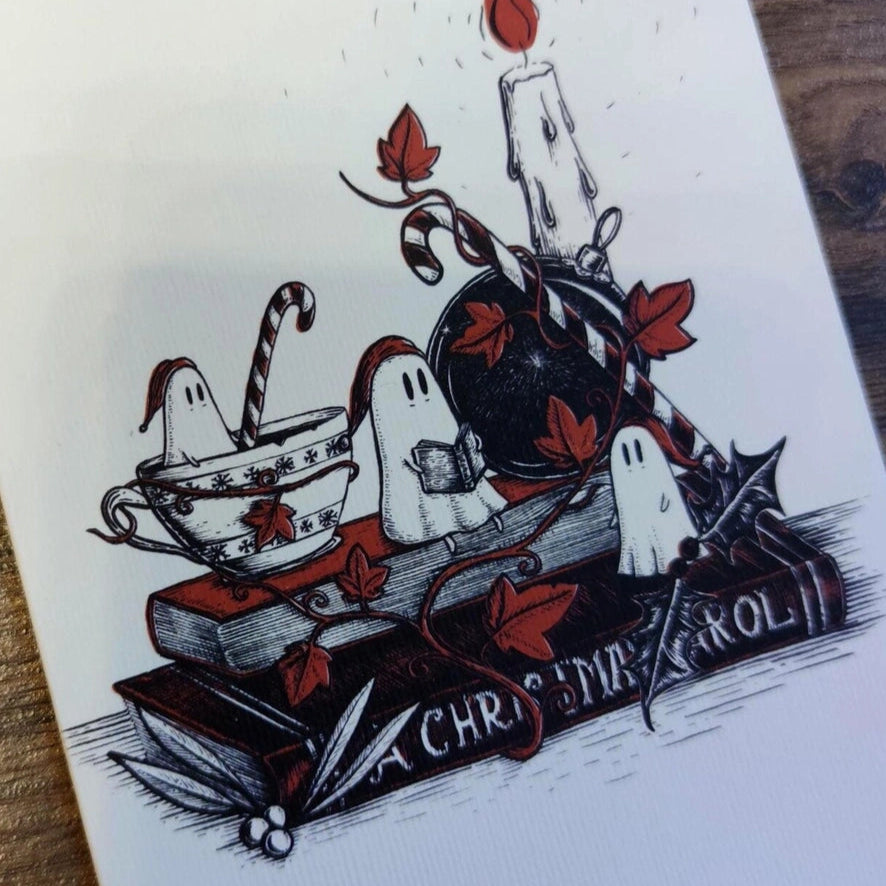 Greeting card with Christmas-themed design featuring candles, ghosts, and candy canes on a wooden surface.