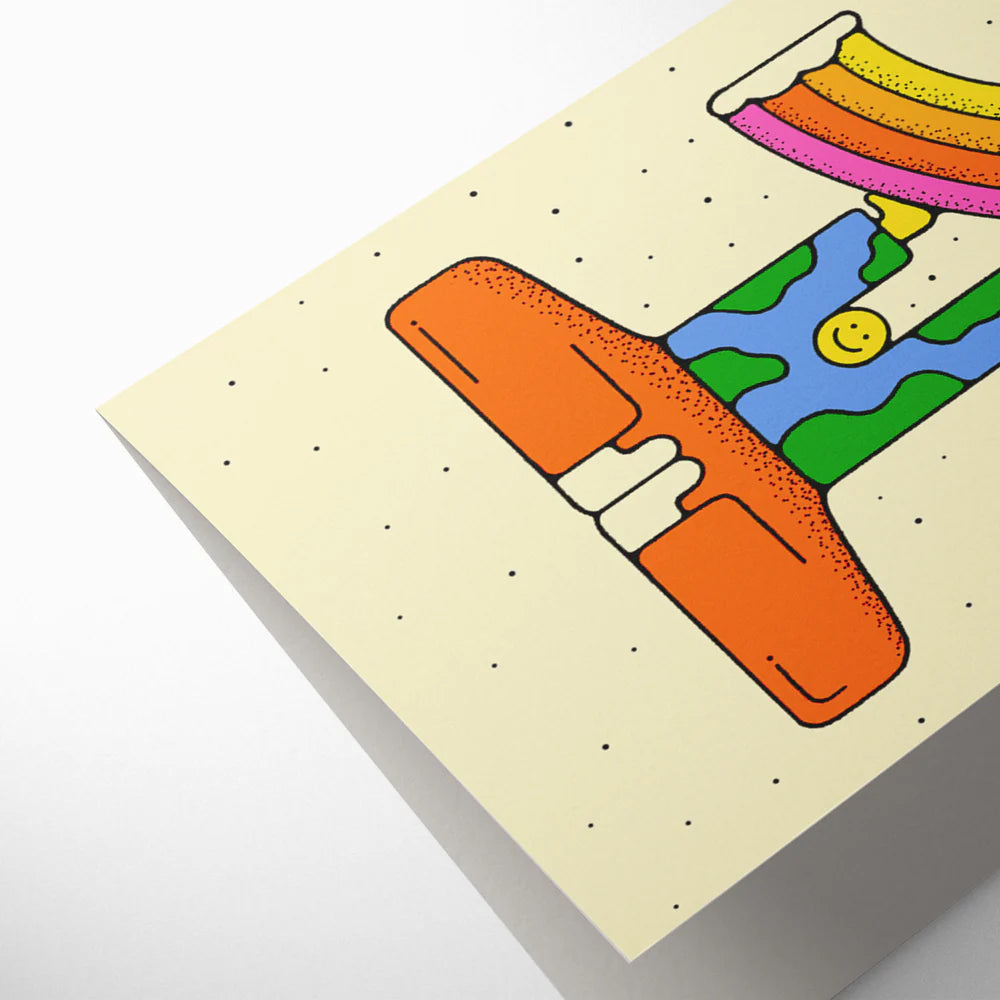 Closeup of beige card with the figure one made from a smiley character holding a rainbow.