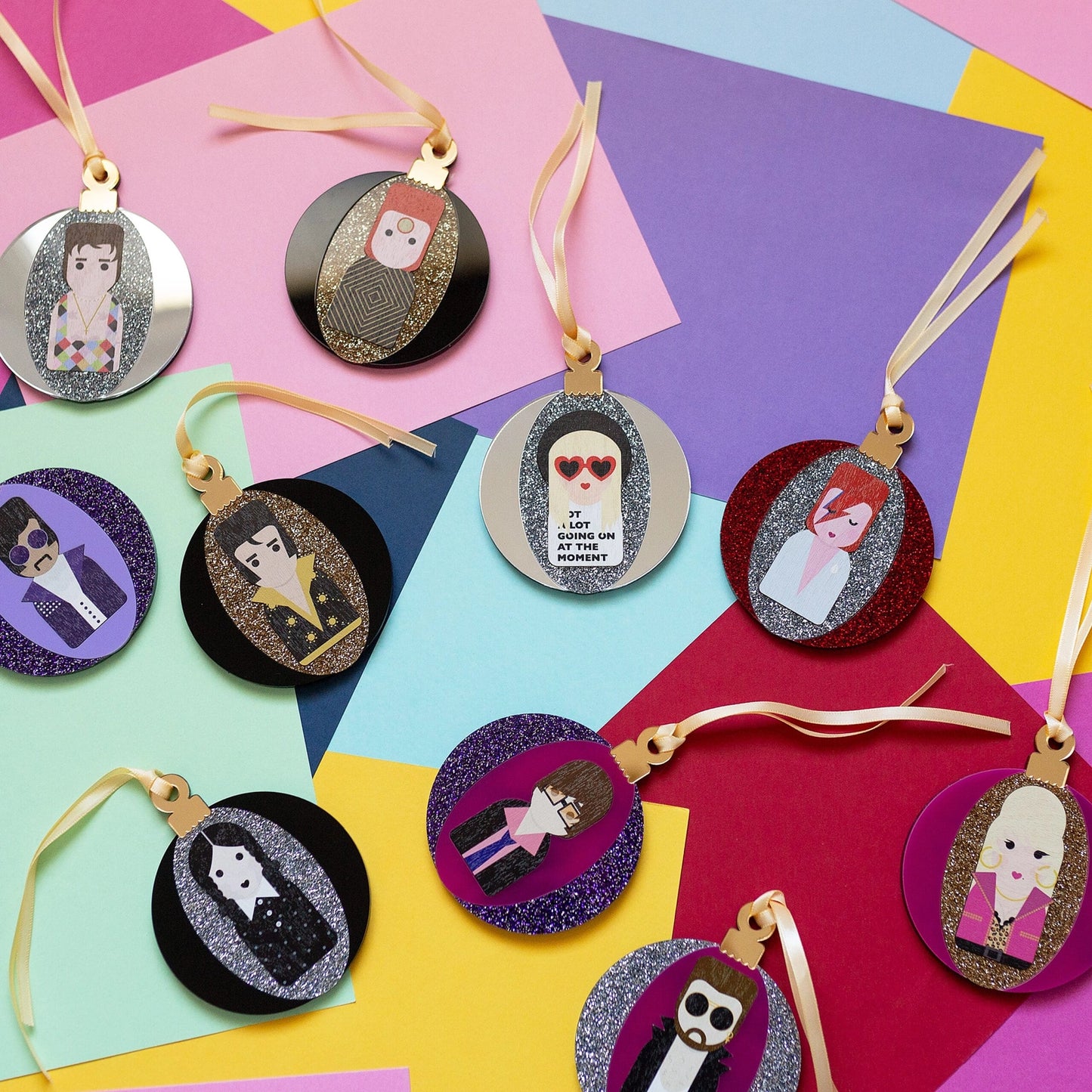 Selection of glittery acryclic baubles featurning music icons, on a colourful background.