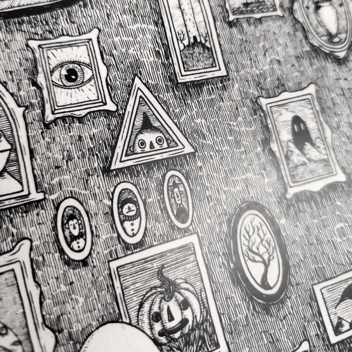 A closeup section of an illustrated black and white print, featuring framed spooky images.