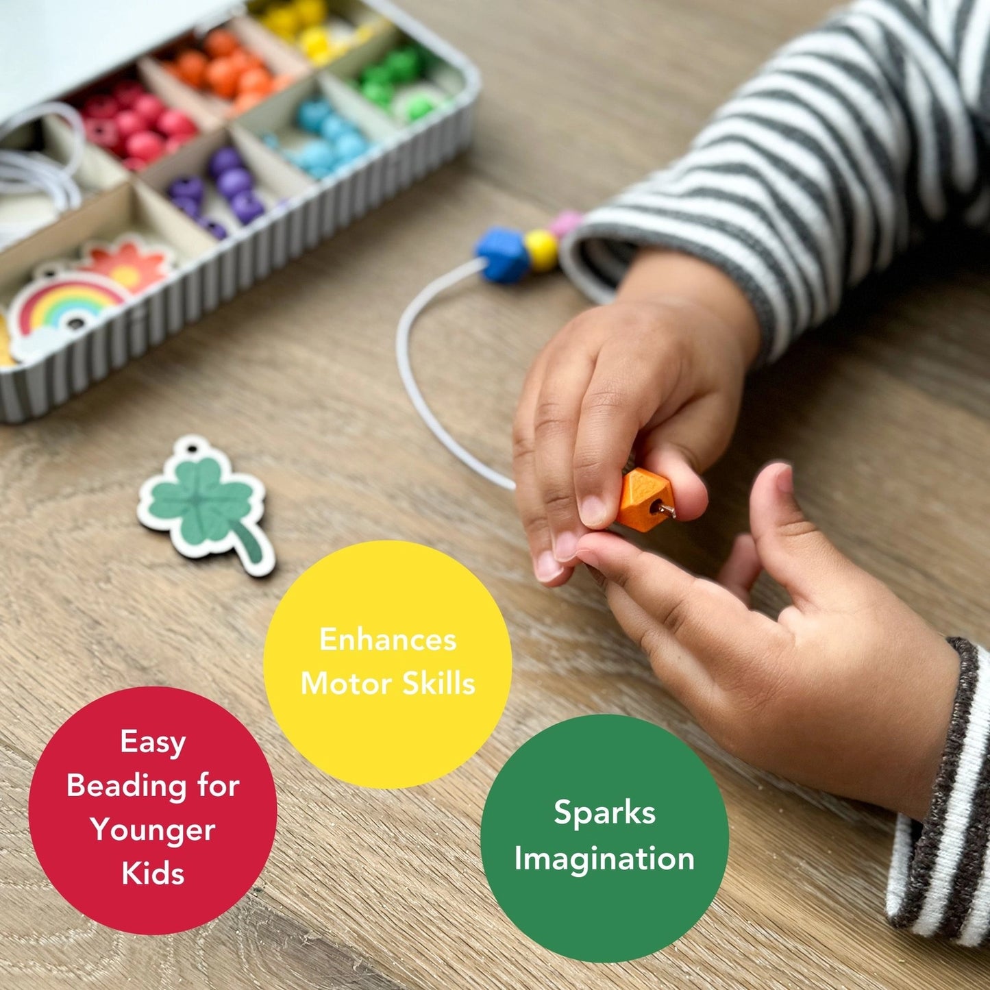 Child's hands playing with colorful beads and educational toys on a wooden surface.