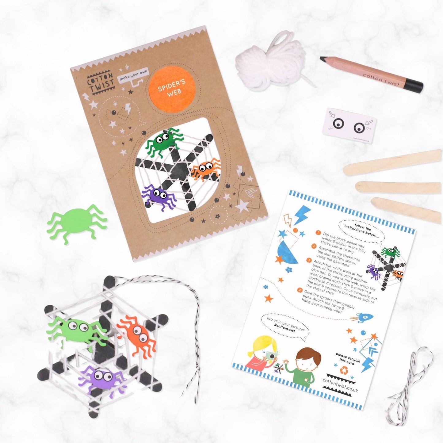 Spider web craft kit with materials on a white background