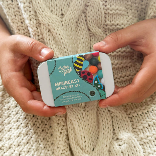 Cotton Twist Minibeast Bracelet Kit held by hands on a knitted fabric background