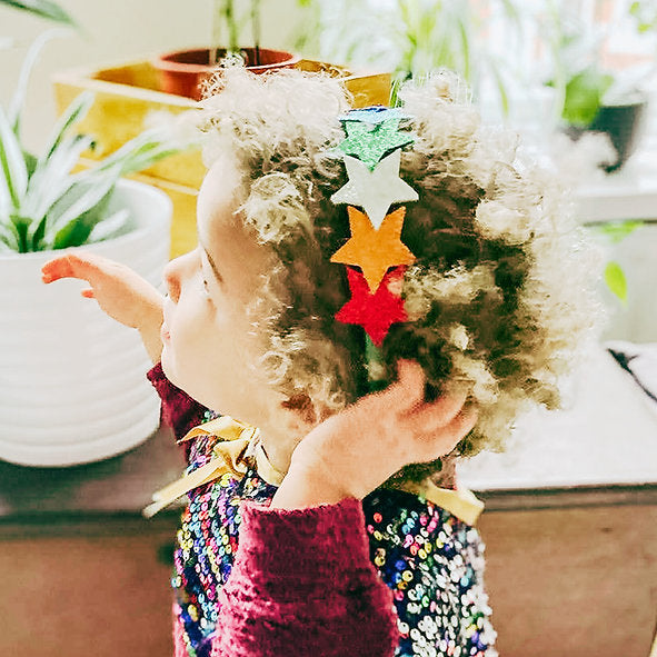 Child with decorative stars in their hair in a home setting