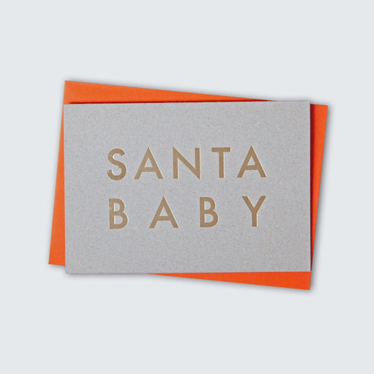 Recycled grey cardboard greeting card with handfoiled 'Santa Baby' text in capitals, in brass foil. Orange envelope.