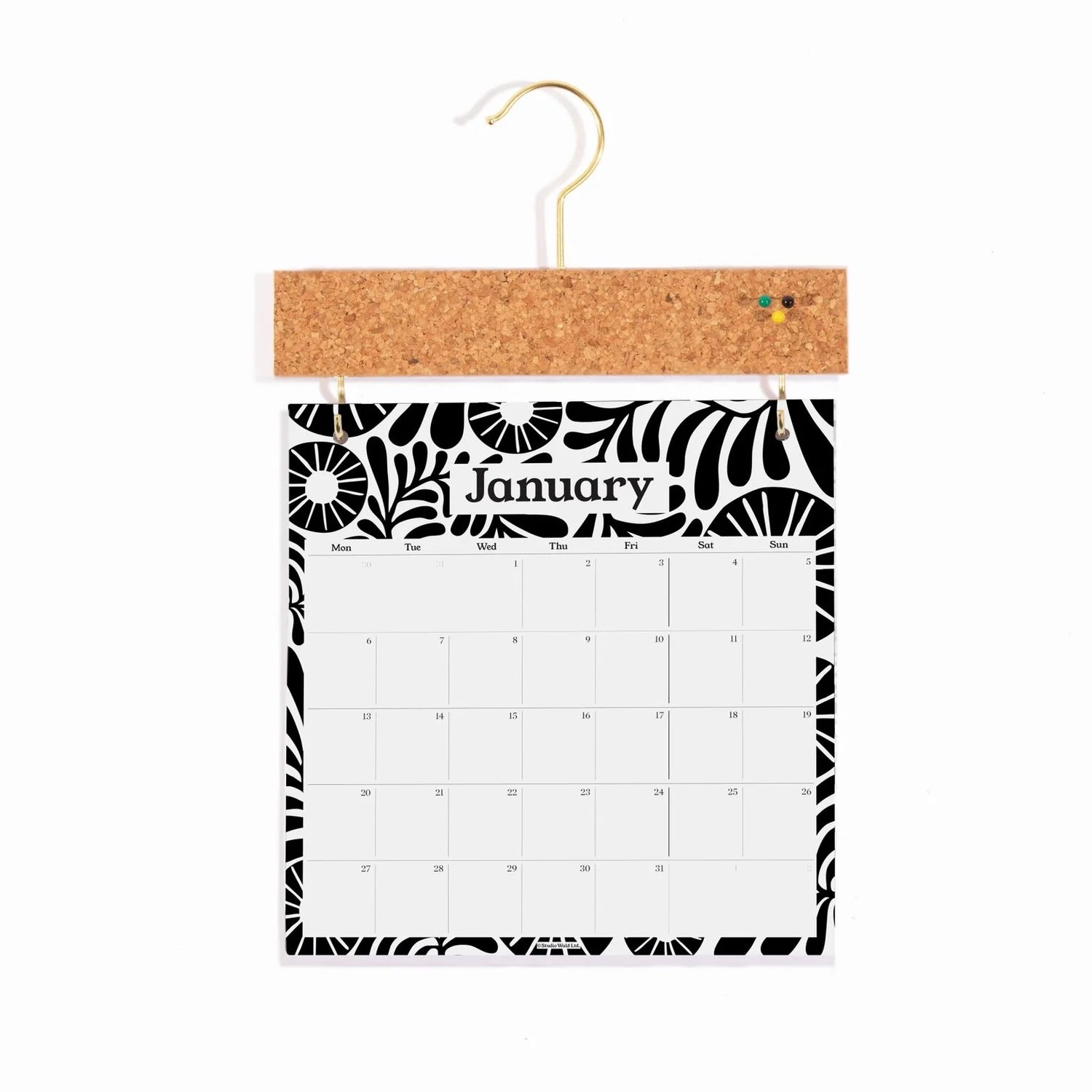 Monochrome floral month by month calendar, hung on a cork pinboard holder. Showing the month of January.