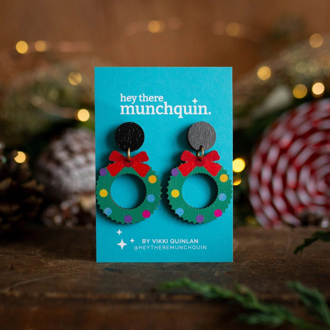 Colourful christmas wreath earrings with a festive backdrop.