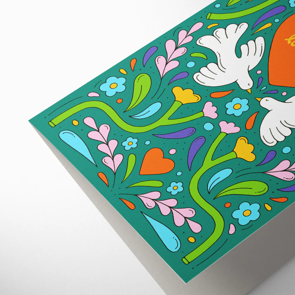 Details of colorful decorative paper with floral patterns, hearts, and doves on a white background.