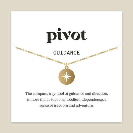 A bronze compass pendant necklace on a delicate chain, presented on a white display card with the brand name 'pivot' and the word 'GUIDANCE' printed above it, set against a warm beige background.