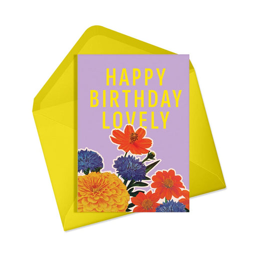Purple card with colourful flowers and the text 'Happy Birthday Lovely' in yellow, with a yellow envelope, on a white background.