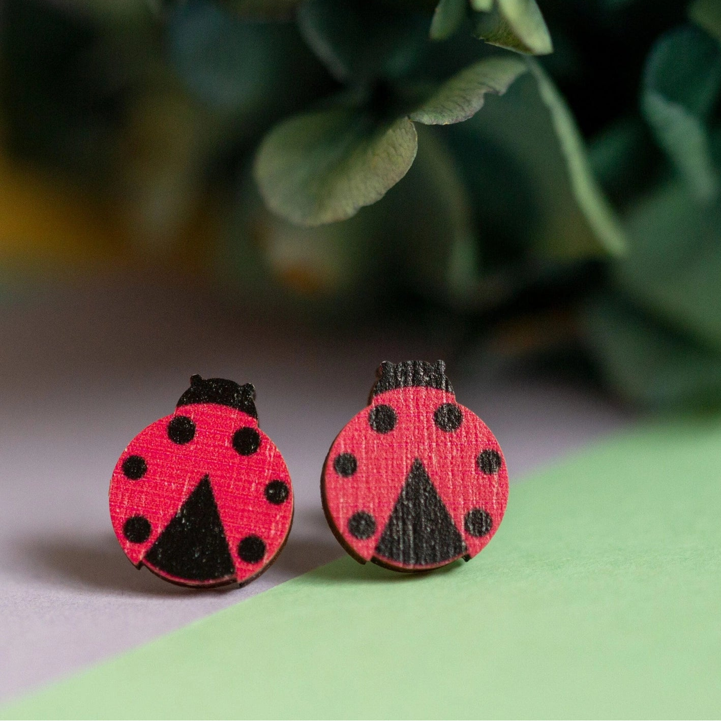 Red ladybug studs, on a green background.