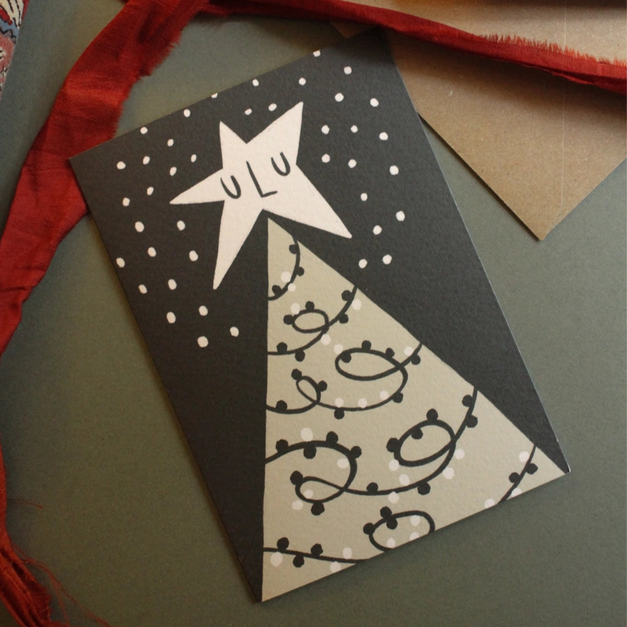 Decorative card with star design and red ribbon on a textured surface