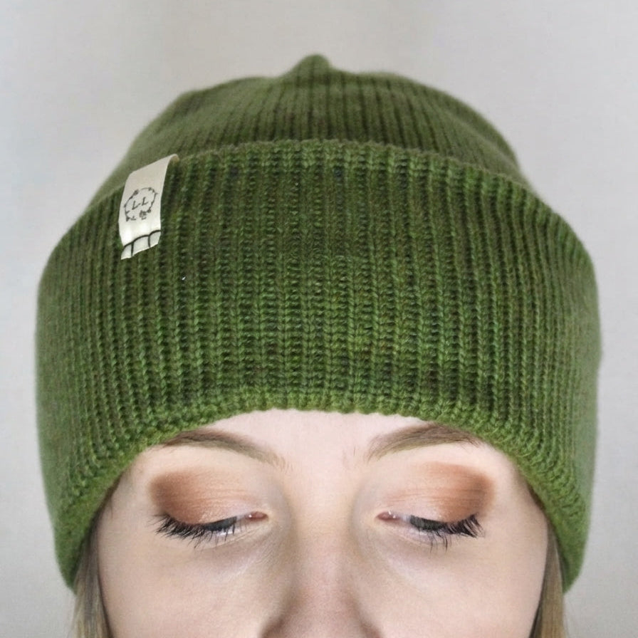 Model wearing an olive green beanie hat.