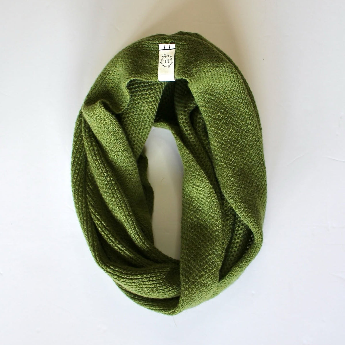 An olive green knitted infinity snood scarf, styled in a loop on a white background.
