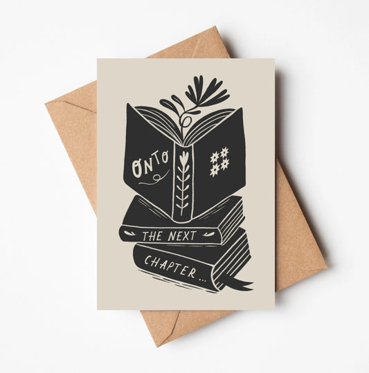 Greeting card with 'Onto the Next Chapter'  book stack design on a beige background with a brown envelope.