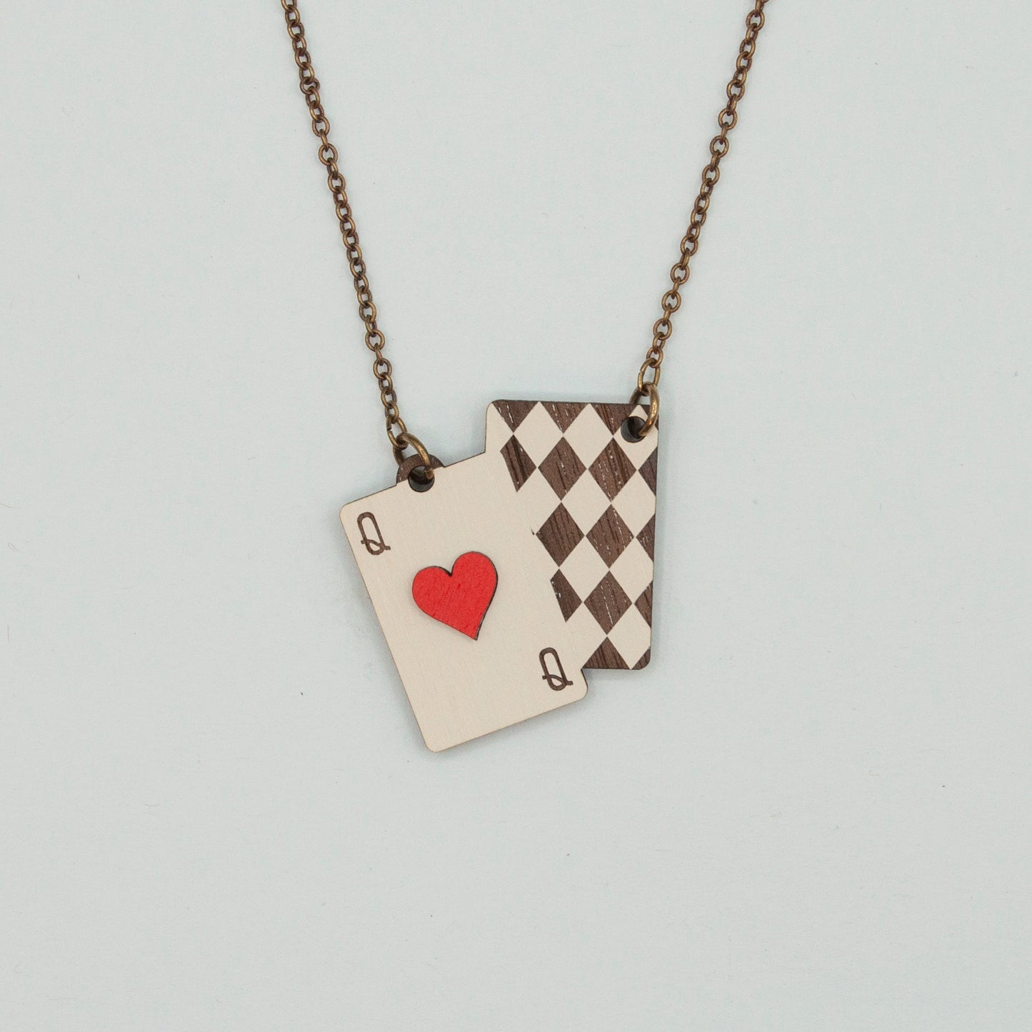 Necklace with playing card charms on a light gray background