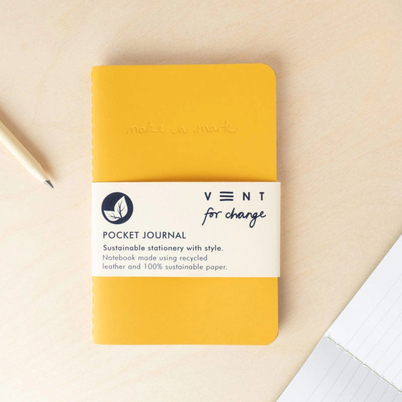 Yellow pocket journal with 'Vent for Change' branding on a beige background