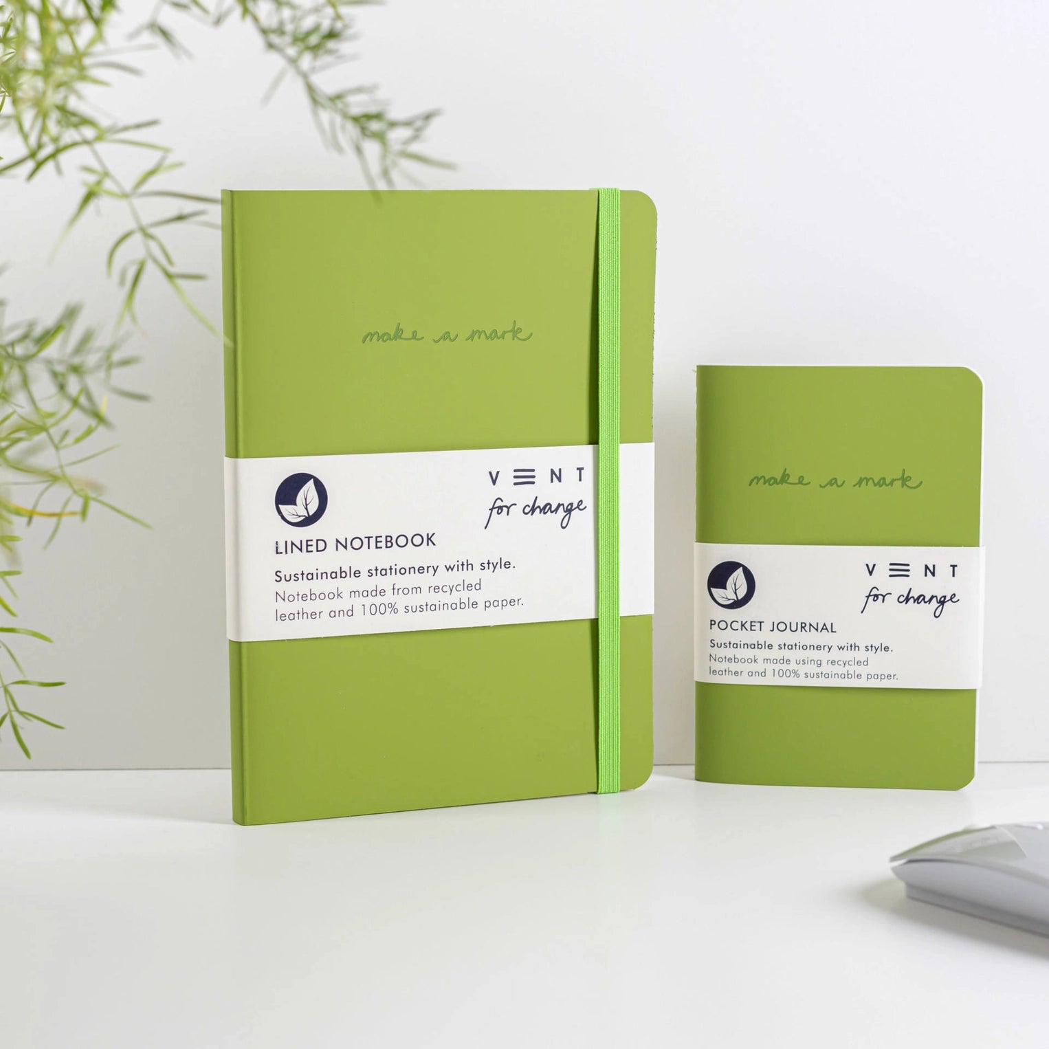 A5 and A6 green leather notebooks stood against a grey background.