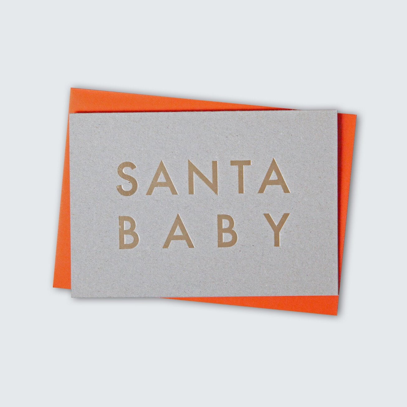 Recycled grey cardboard greeting card with handfoiled 'Santa Baby' text in capitals, in brass foil. Orange envelope.