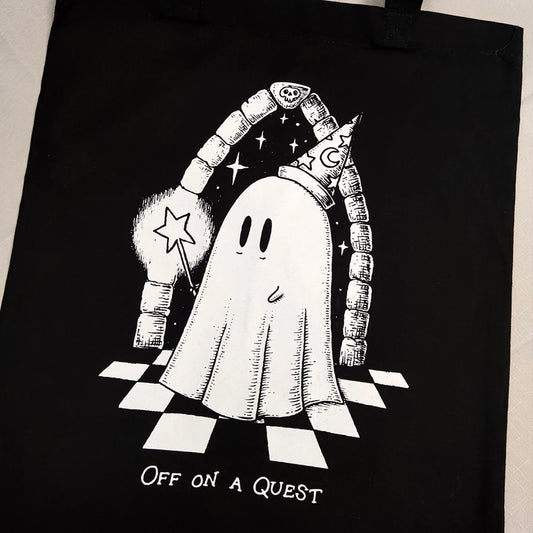 Black tote bag with a white ghost illustration and 'Off on a Quest' text.